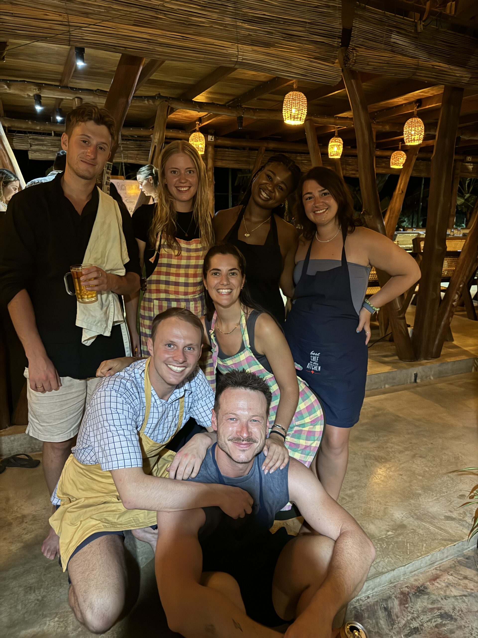 People in aprons standing and smiling with one another while staying in hostels