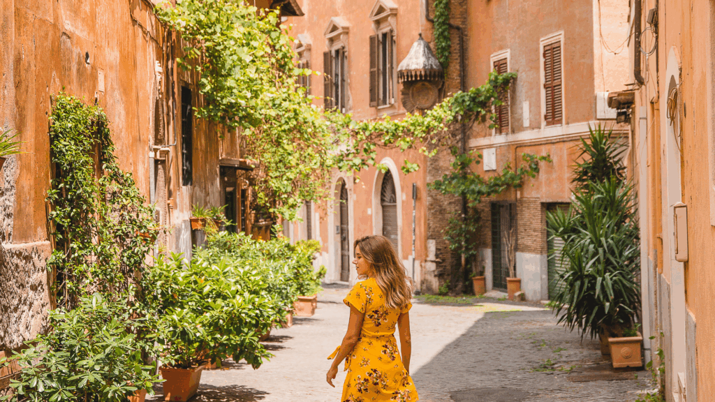 Woman in yellow dress walks down street with green ivy